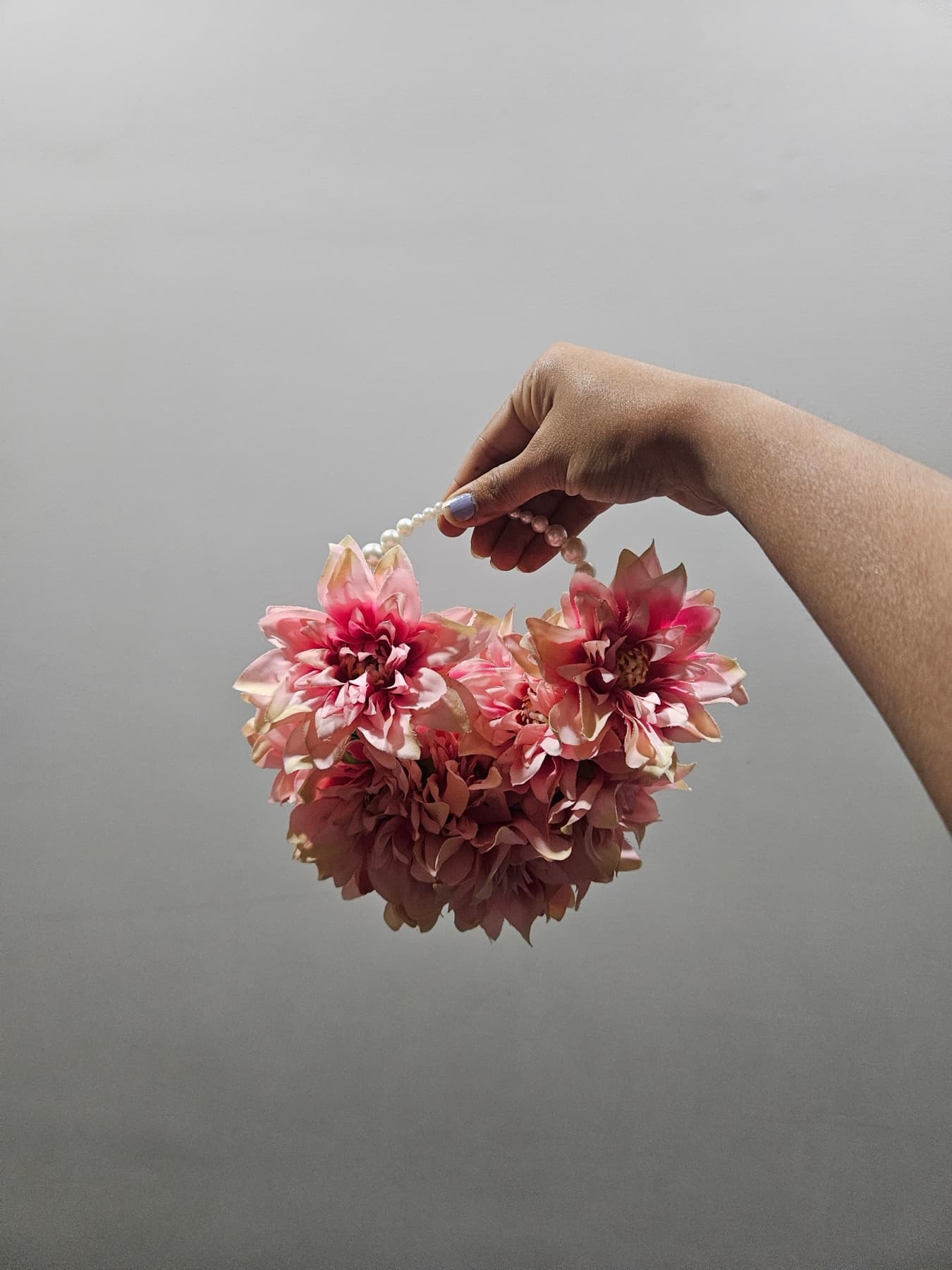Deep red lotus purse bouquet held in one hand