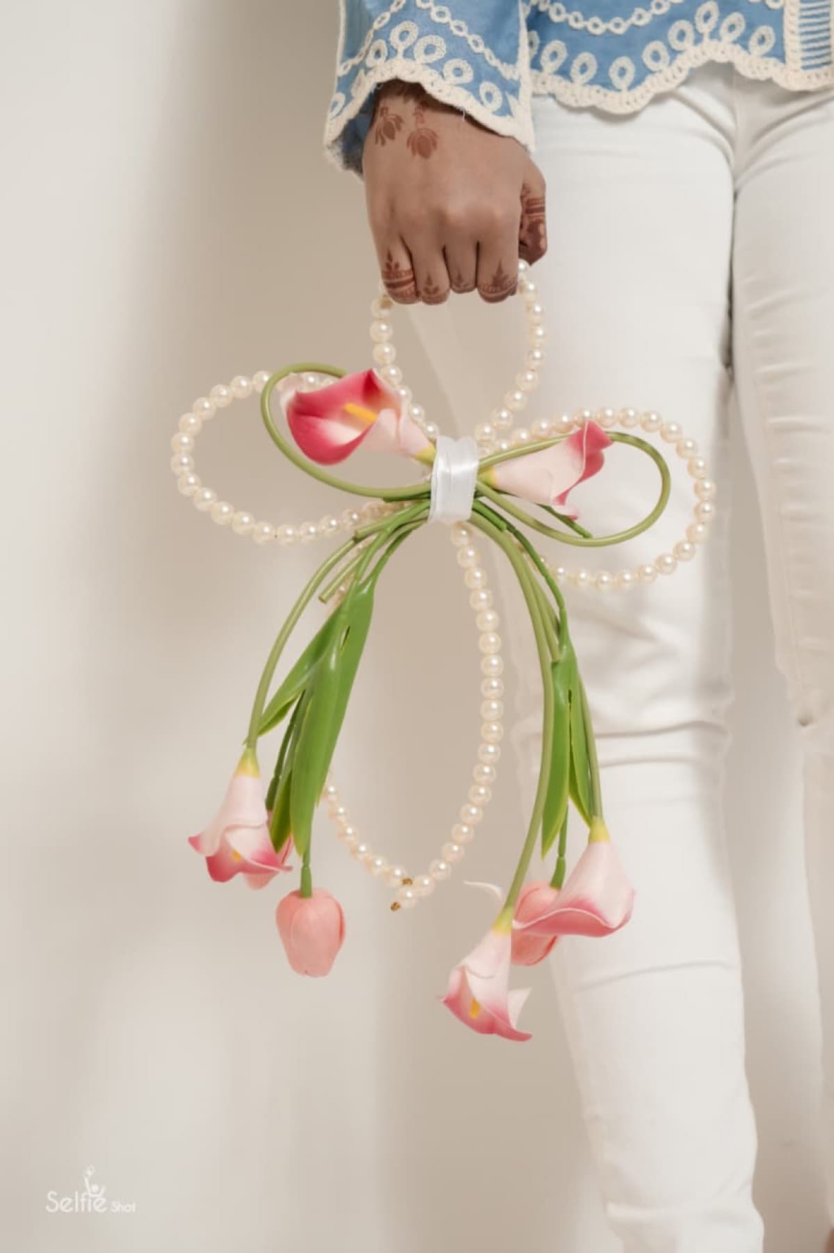 Blush calla lily purse bouquet with a looped pearl bow handle