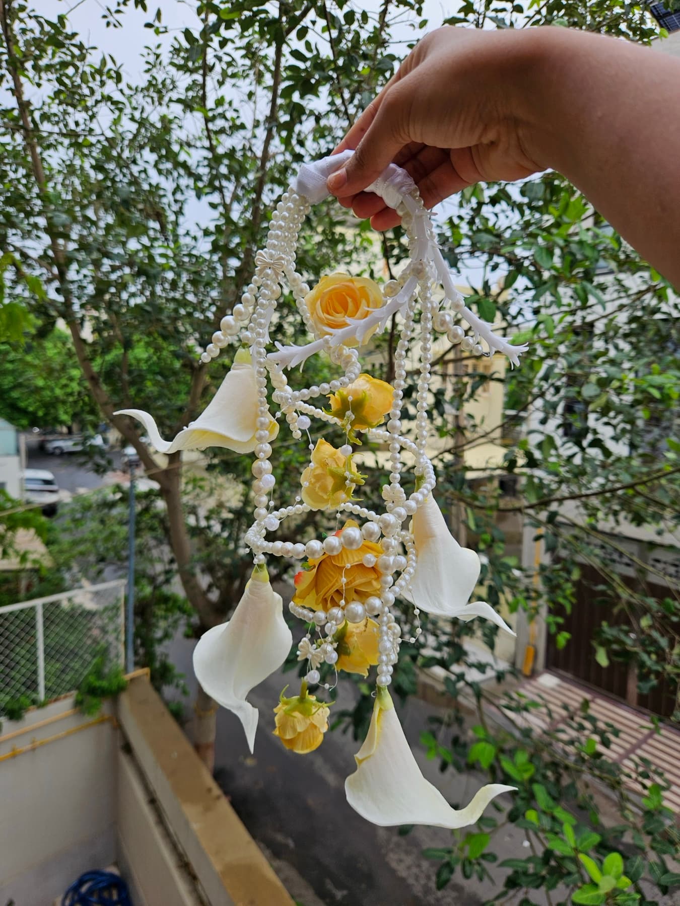 Yellow calla lily purse bouquet held up outdoors