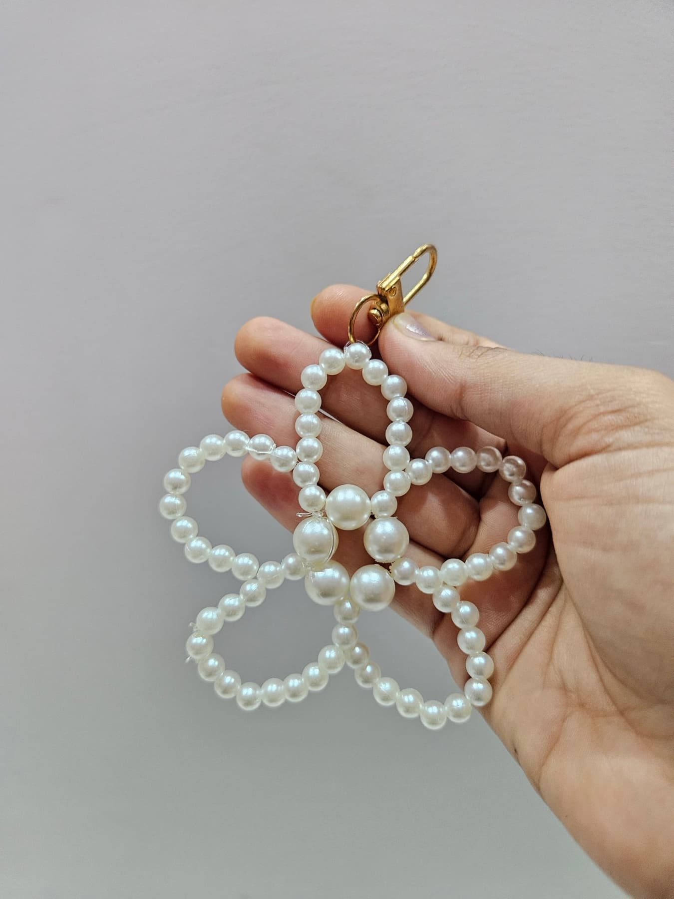Pearl flower charm held between two fingers