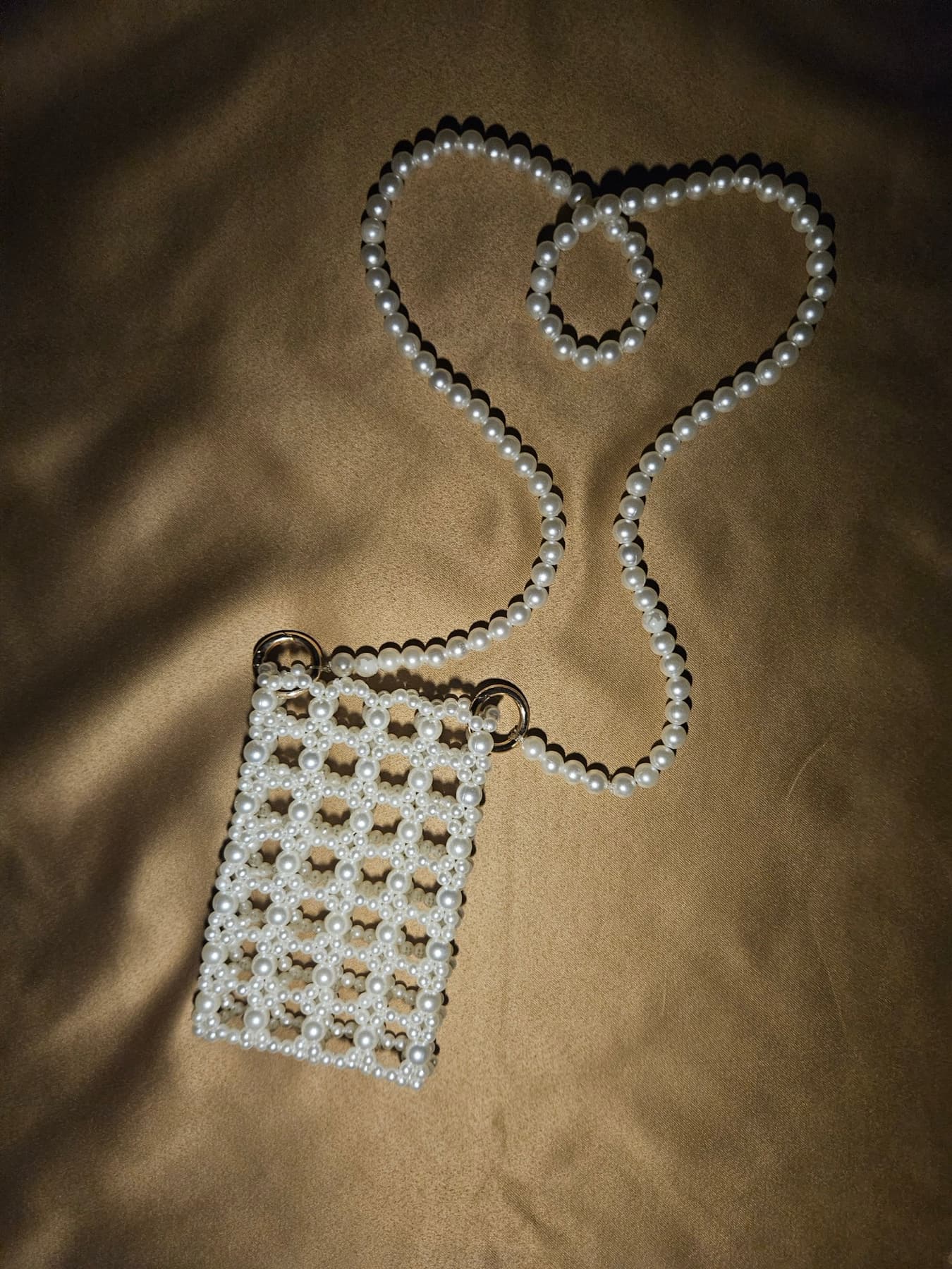 Pearl phone pouch with heart-shaped pearl chain on gold silk